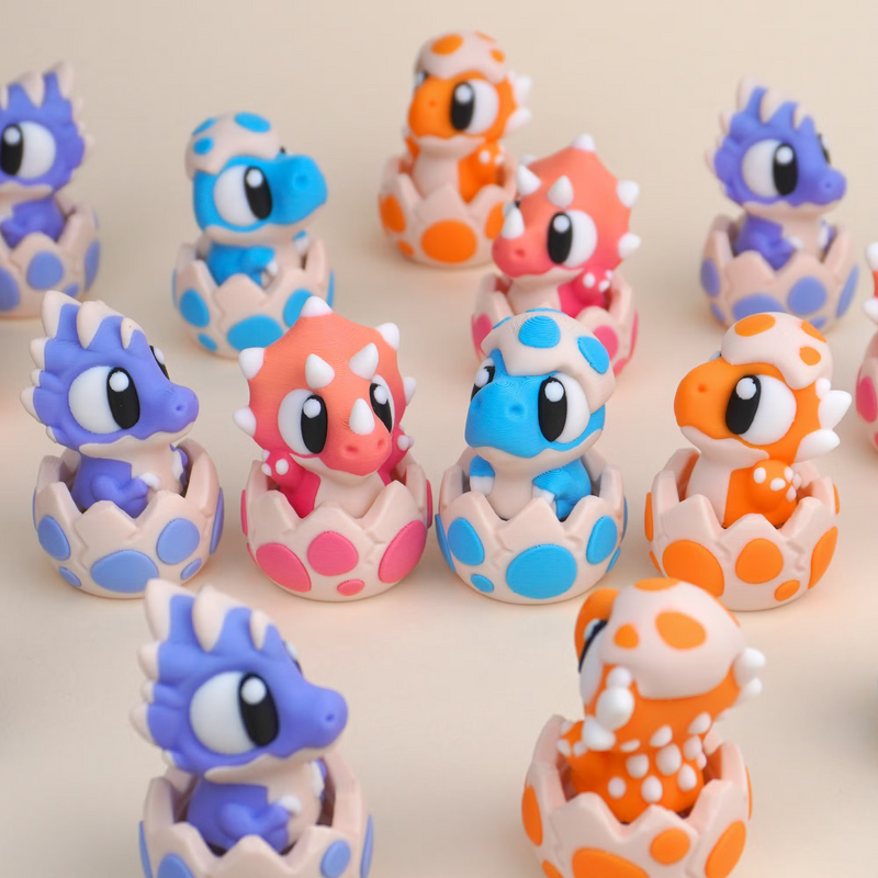 Baby Dinosaur Clicker Toy group shot showing all four hatching dinosaur characters, T-rex, Triceratops, Velociraptor and Ankylosaurus, each in its own spotted eggshell clicker