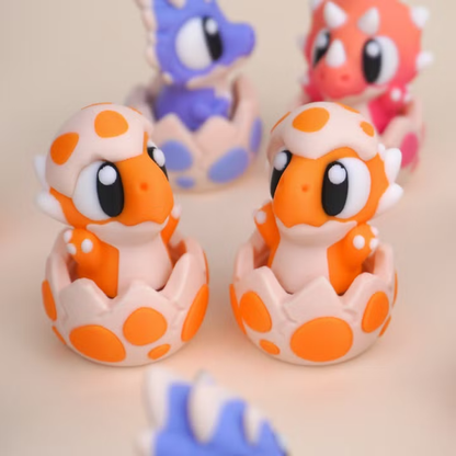 Baby Dinosaur Clicker Toy, orange dinosaur character in its eggshell, close-up pair view