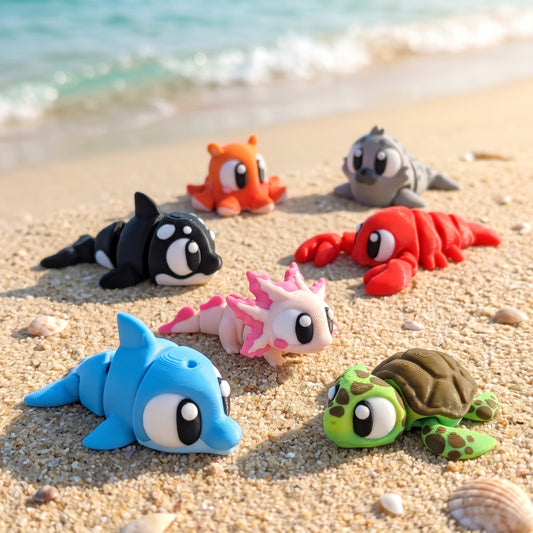 Build Your Own Ocean & Sea Bundle, 3D Printed — dolphin, axolotl, sea turtle, killer whale, lobster, dumbo octopus, and seal Flexi toys on a sandy beach